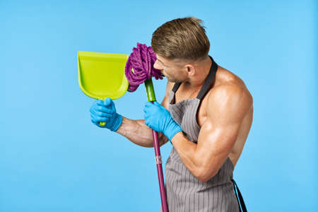 man in apron with mop posing muscular body houseworkの写真素材