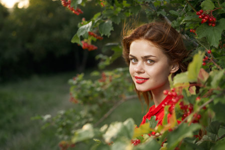 cheerful woman in a red shirt bush berries countryside