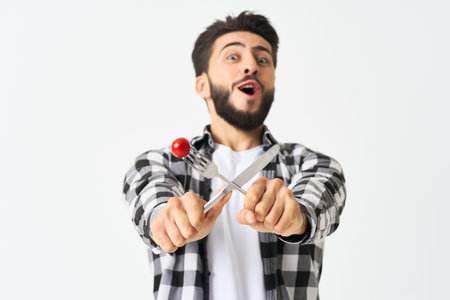 bearded man with kitchen utensils cherry tomatoes snack