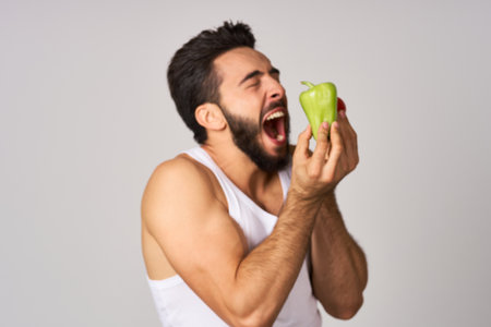 a man in a white t-shirt with vegetables in his hands healthy food dietの写真素材