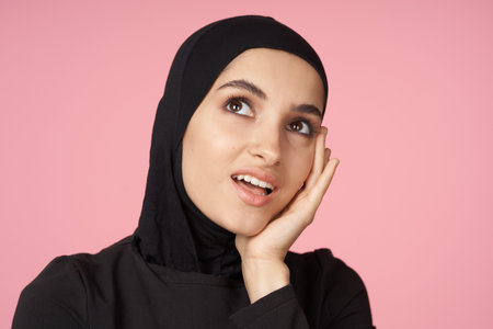 cheerful muslim woman black hijab posing hand gesture pink background