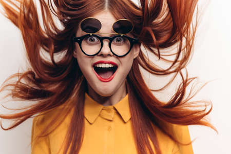 red-haired woman wearing sunglasses posing fashion light backgroundの写真素材