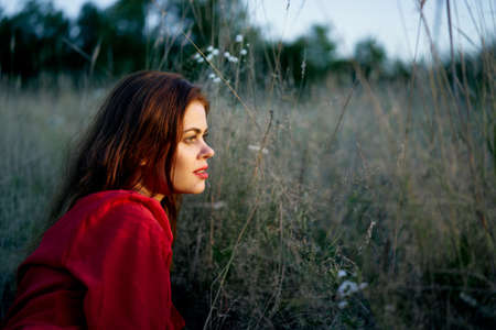 pretty woman in red dress lies on the grass nature sunの写真素材