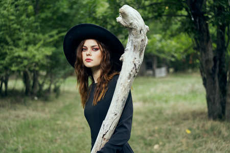 woman in black witch costume in forest nature posingの写真素材