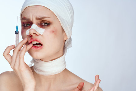 emotional woman woman after surgery syringe in hand injection studio lifestyleの写真素材