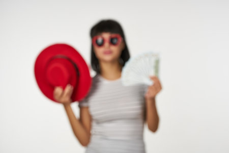 woman in a striped t-shirt wearing glasses with money in hands wealth financeの写真素材
