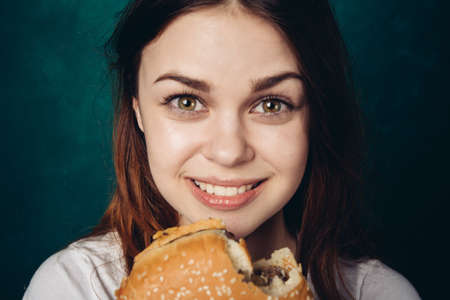 woman eating hamburger fast food snack close-upの写真素材