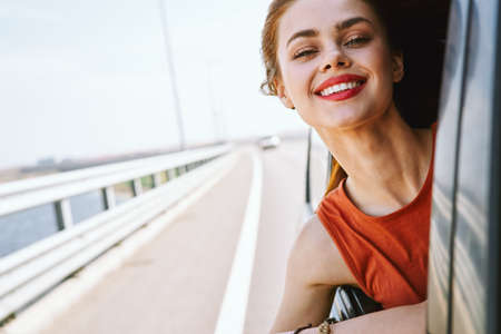 cheerful woman car ride road travel adventureの写真素材