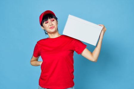 woman with box in hands delivery courier blue backgroundの写真素材