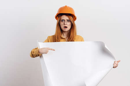 female engineer in orange hard hat blueprints architectの写真素材