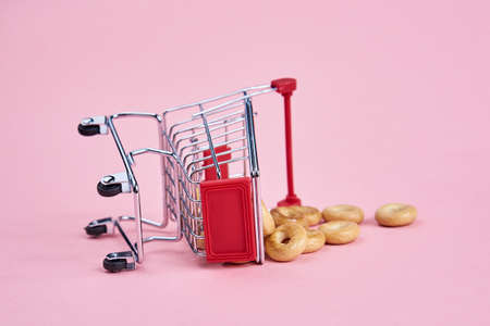 small shopping carts supermarket shopping pink backgroundの写真素材