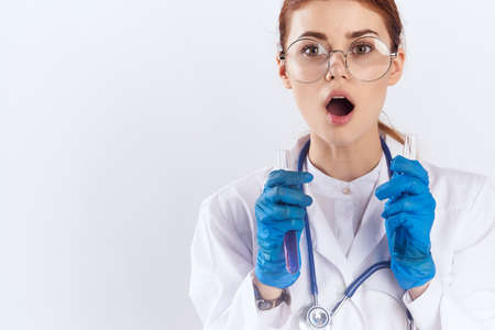 female doctor sitting at the table with blue gloves medication testsの写真素材