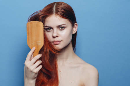 pretty woman combing hair bare shoulders hair careの写真素材