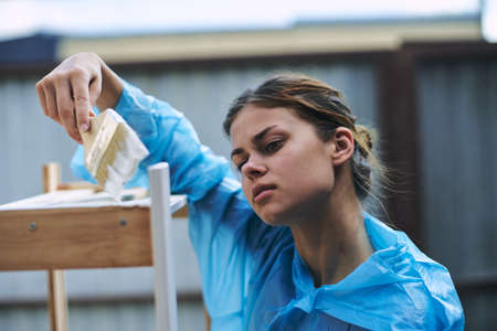 cheerful woman with a paint brush to paint wooden fittingsの写真素材