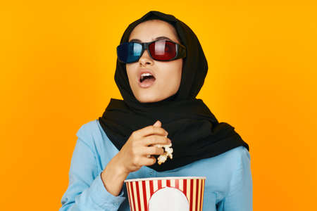 arab woman entertainment going to the cinema popcorn yellow backgroundの写真素材