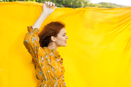 smiling woman in yellow dress posing nature yellow cloth