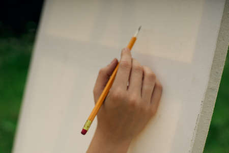 female hand with pencil easel drawing close upの写真素材