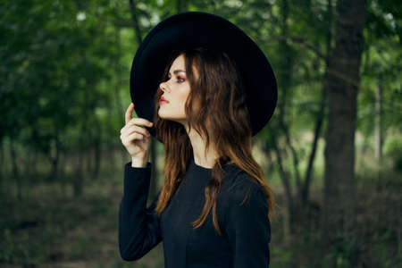 woman witch in black hat in the forest posing fantasyの写真素材