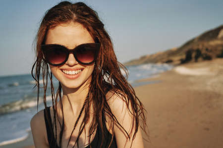cheerful woman in sunglasses in a swimsuit on the beach sun islandの写真素材