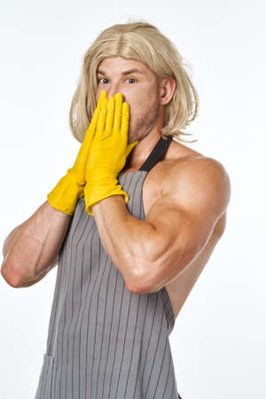 man in yellow rubber gloves in a womans wig cleaning posingの写真素材