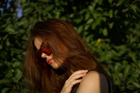 fashionable woman in sunglasses and green leaves summer exotic