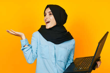 woman in black hijab with laptop in hands technology emotions studio lifestyleの写真素材