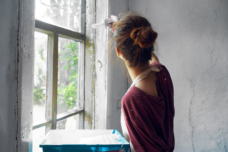 woman with brush paint window home renovation interior