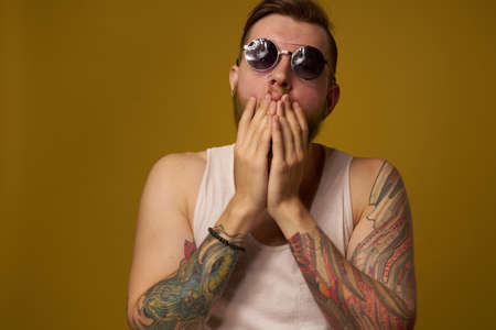 man in a white t-shirt tattoos on his arms fashion glasses modern styleの写真素材