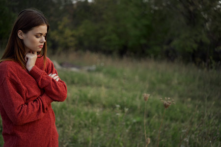woman in a red sweater outdoors in a field walk
