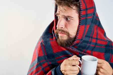 cold man with blanket warming drink health problemの写真素材
