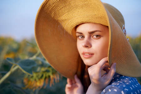 pretty woman with hat in the field of sunflowers freedom natureの写真素材