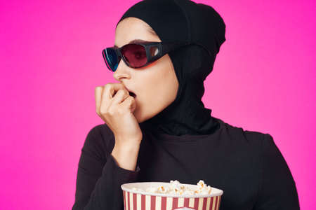 arab woman attractive look popcorn glasses movie watching isolated backgroundの写真素材