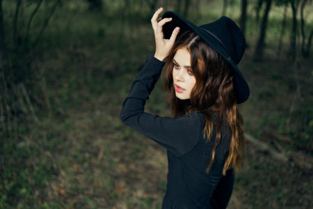 woman in the forest in a black hat gothic style Witch costumeの写真素材
