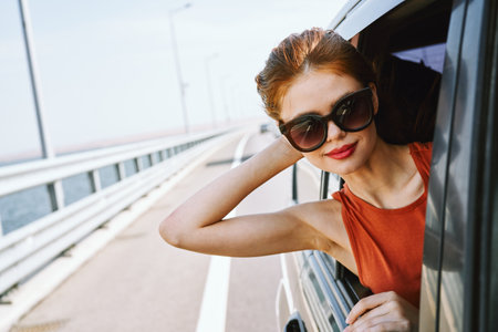 woman looking out of car window wearing sunglasses travel lifestyleの写真素材