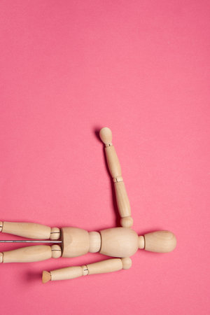 wooden mannequin on pink background posing close-upの写真素材