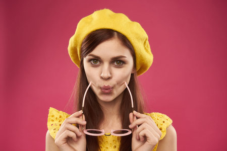 glamorous woman in yellow hat glasses posing