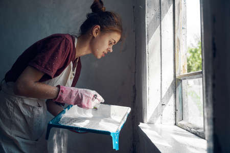 woman painter paint window home interior renovationの写真素材