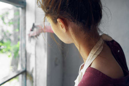 woman with brush paint window home renovation interiorの写真素材