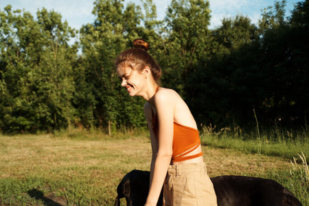 Cheerful Woman and a dog in the nature games Friendship