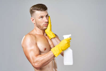 man with pumped muscles detergent posing cleaningの写真素材