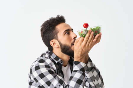 emotional bearded man in plaid shirt plate with saladの写真素材