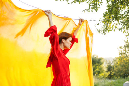 pretty woman in red dress hairstyle posing natureの写真素材