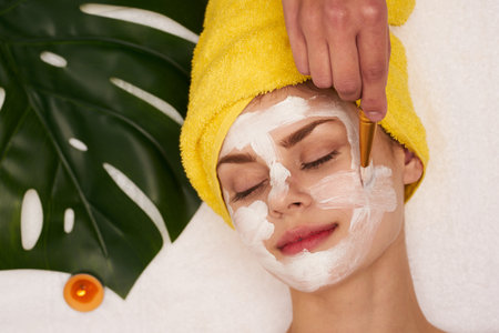 cheerful woman spa treatments cosmetics beauty saloon light backgroundの写真素材