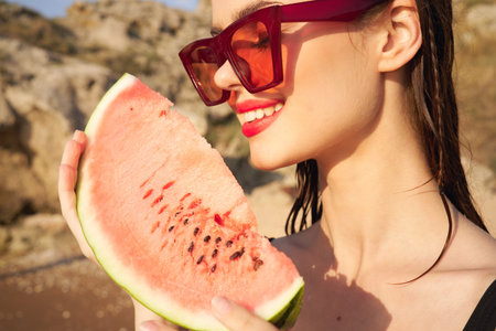 cheerful woman in sunglasses and watermelon nature rocksの写真素材