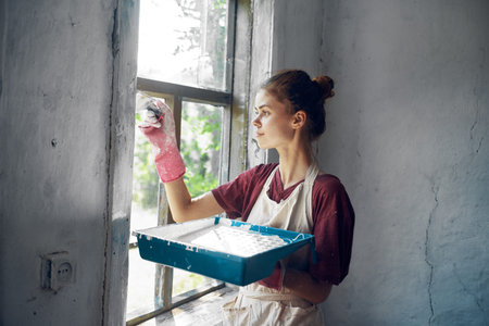 woman in apron painter repair painting window