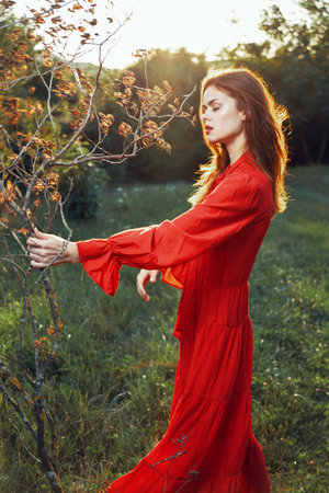 woman in red dress in field near tree posing summer