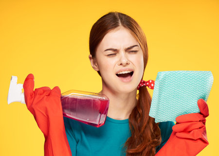 woman in rubber gloves detergent cleaning housework yellow background