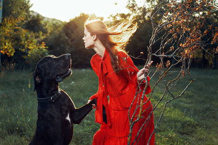 cute woman in red dress playing with dog outdoors friendship
