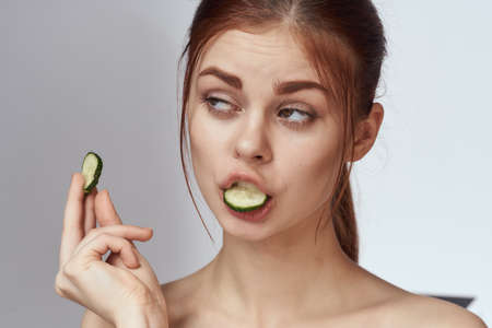 cheerful woman with cucumbers in hands cosmetology vitamins healthの写真素材