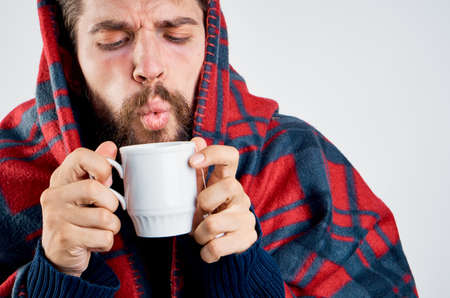 cold man with blanket warming drink health problemの写真素材